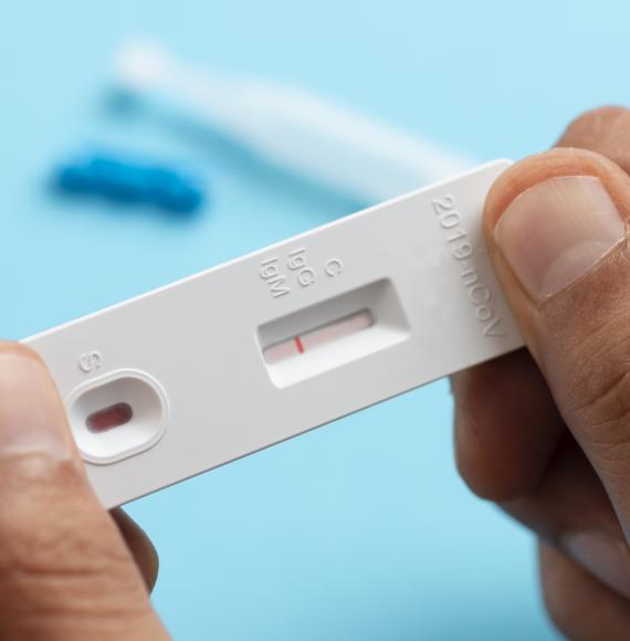 Man looks at lateral flow covid test