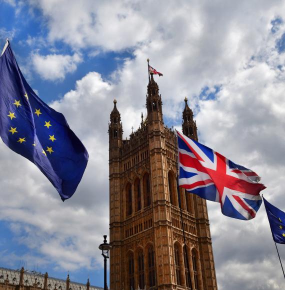 EU and Union Flag fly next to Parliament.