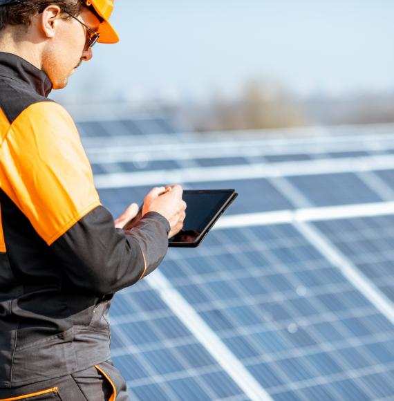 Worker makes note son solar panels that have been installed