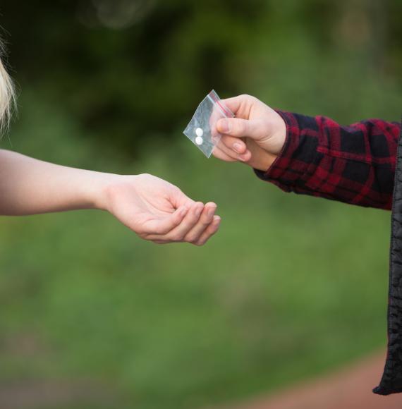 Man hands pills to woman.