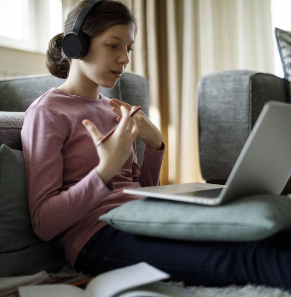 Girl sits in front of laptop remote learning