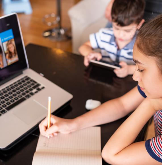 Children sit at laptop e-learning. 