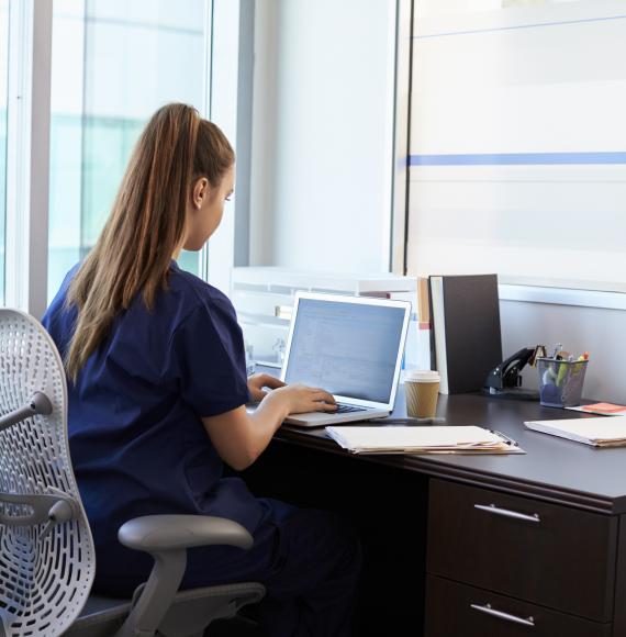 Student nurse sits at desk. 