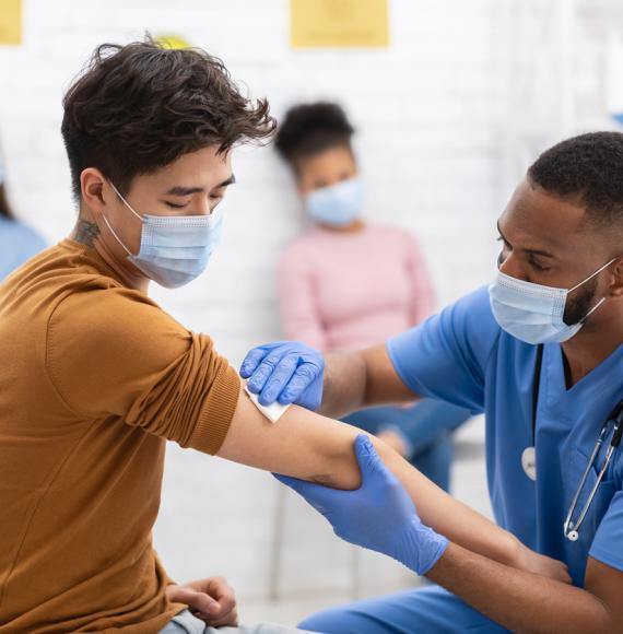 BAME man receives vaccine from nurse.