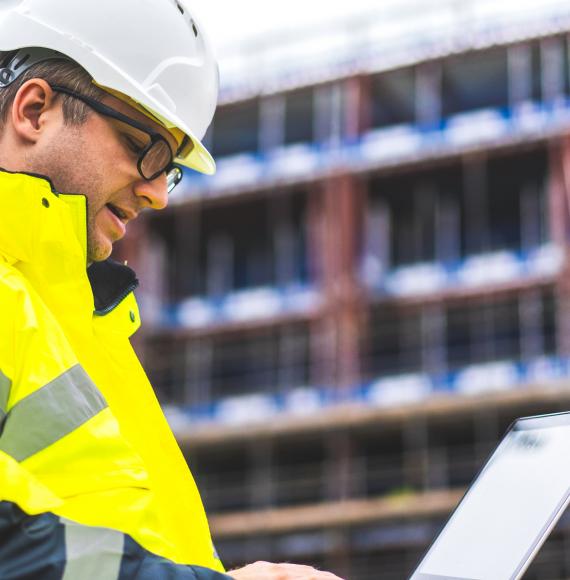 Engineer on building site with laptop