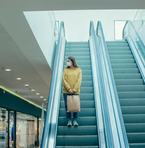 Woman standing on shopping centre escalators