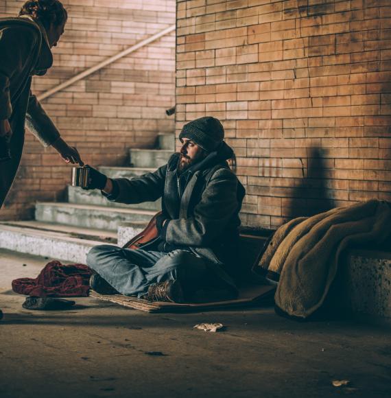 Homeless man and woman giving him money