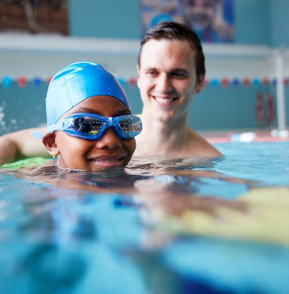 Boy with male swimming coach