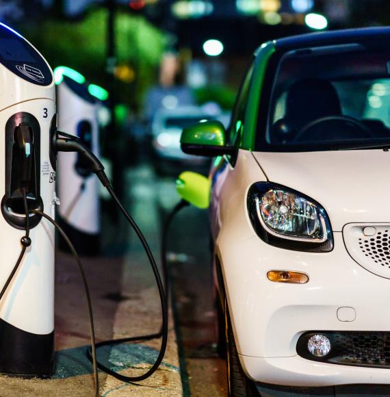 Car plugged into EV charge point on the road side