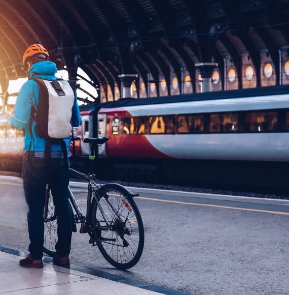 Man and bike, with train in background