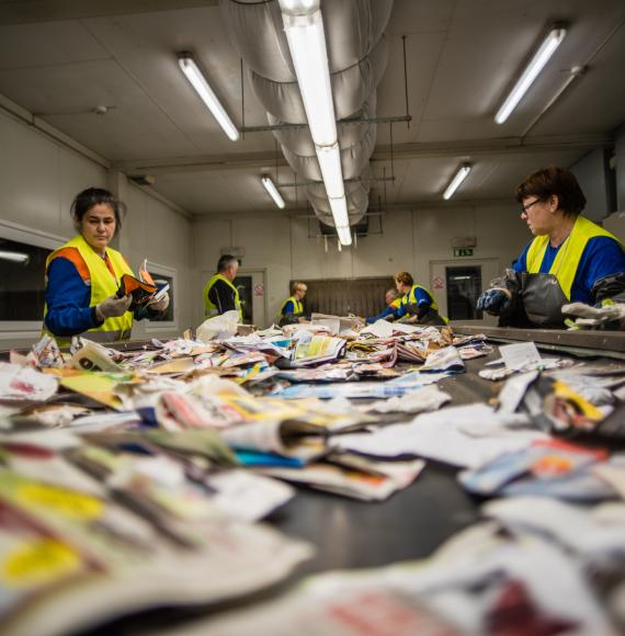 Recycling centre workers sorting out waste