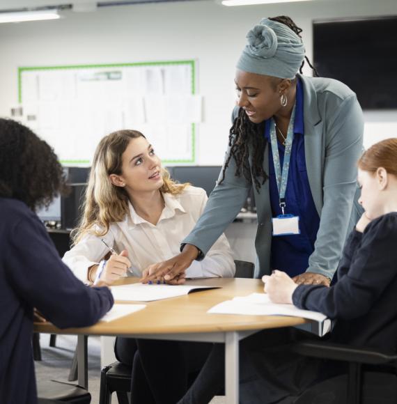 A female teacher helps students with their work