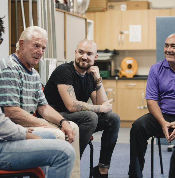 Group of men in community support meeting