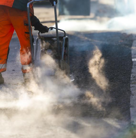 Road maintenance worker resurfacing tarmac