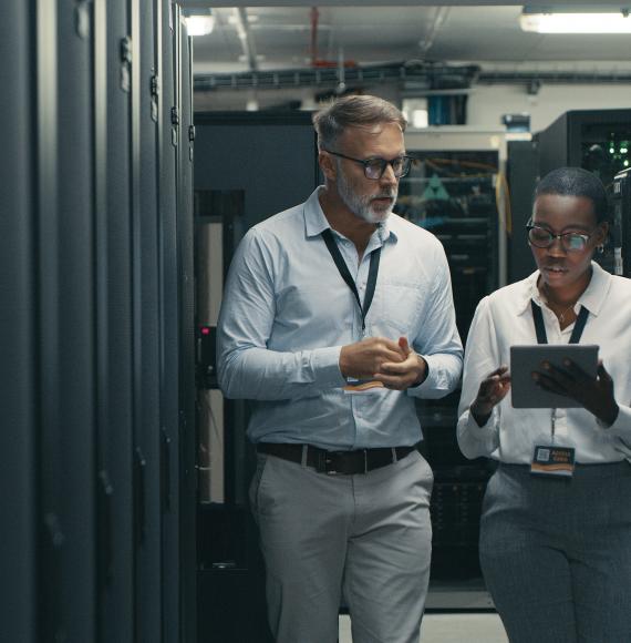 Two people walking through IT infrastructure