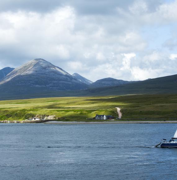 Panoramic view of Scottish island with a boat in the foreground