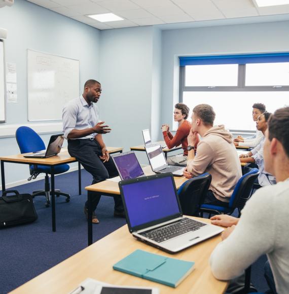 A male teaches a class of further education students