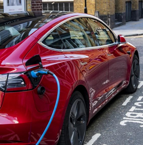 An electric vehicle charging at the side of the road