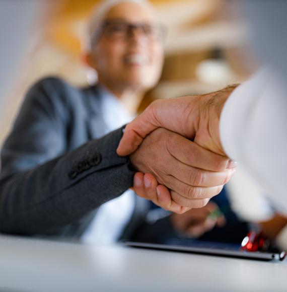 Close up shot of two people shaking hands in a business environment