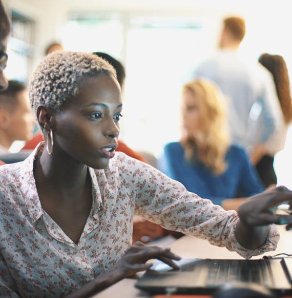 A woman points at a computer