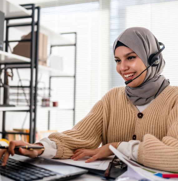Lady in a hijab working at a computer in an office