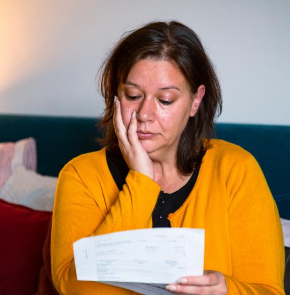 Woman looking sullenly at a bill