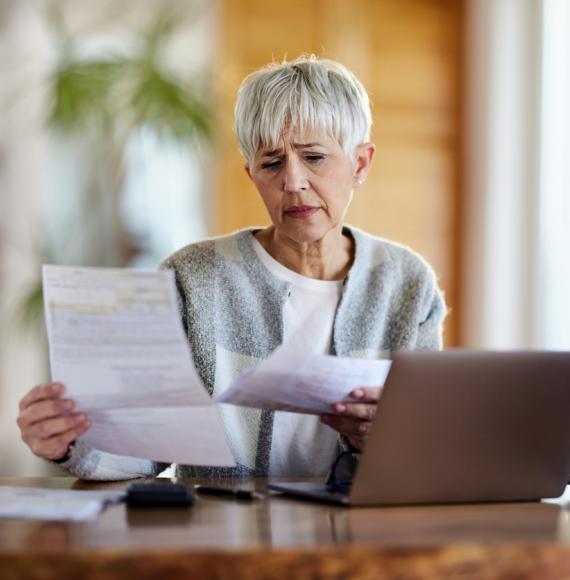 Older woman looking worried when looking at her bills