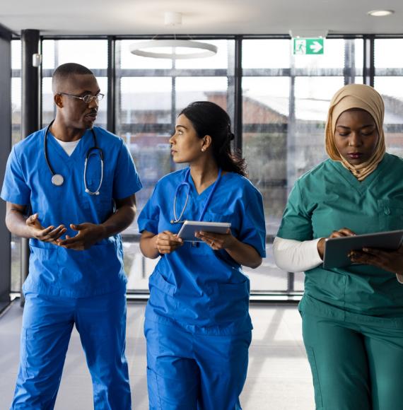 Three healthcare workers walking down a corridor in an English hospital