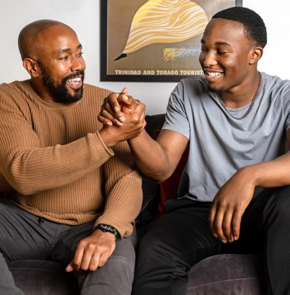 Two young men sat on a sofa