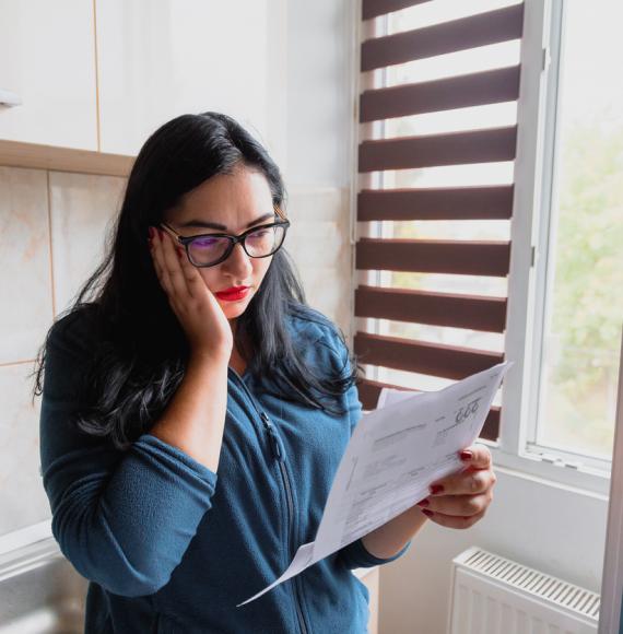 Portrait of a mid adult woman checking her energy bills at home