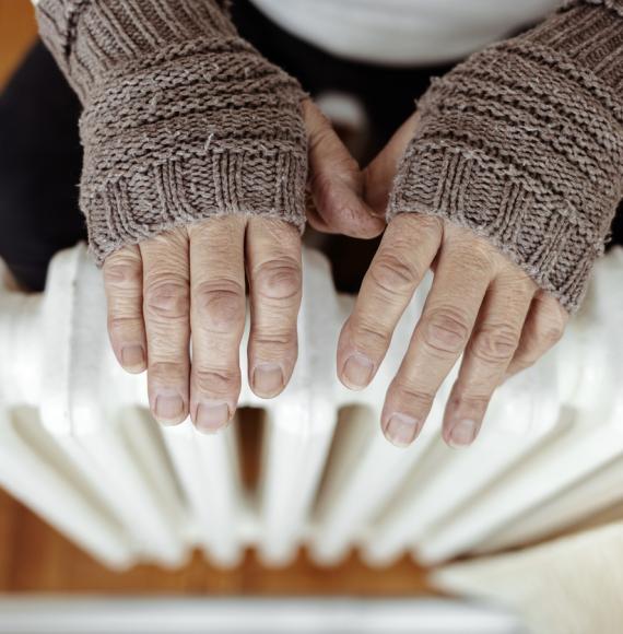 Woman warming hands up on a radiator