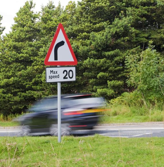 Speed limit sign as car drives past in the UK countryside
