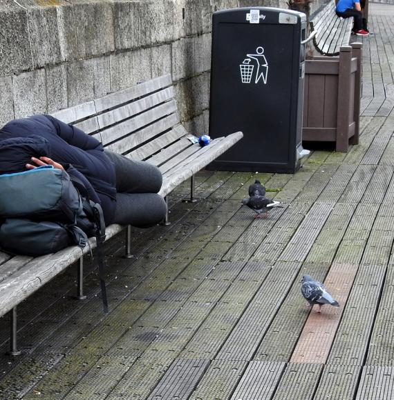 Homeless man sleeping on a bench