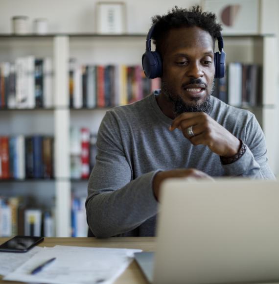 Man with headphones attends an online course at home