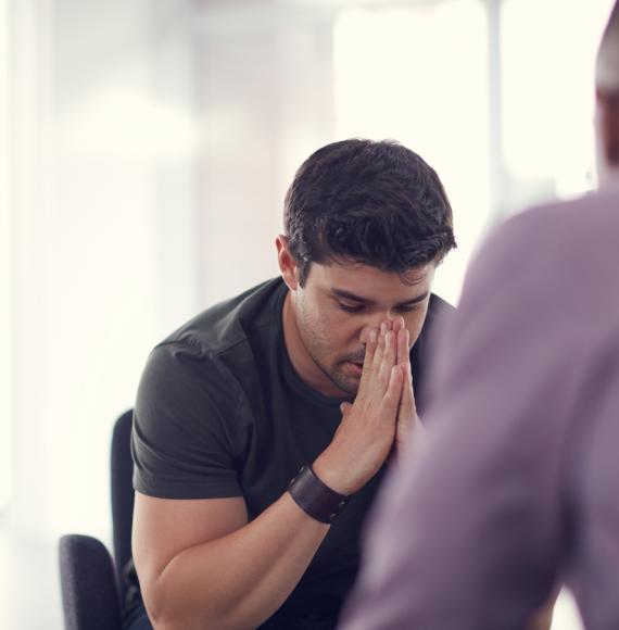 Shot of an unhappy young man talking with a colleague