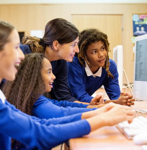 School children gathered round a computer