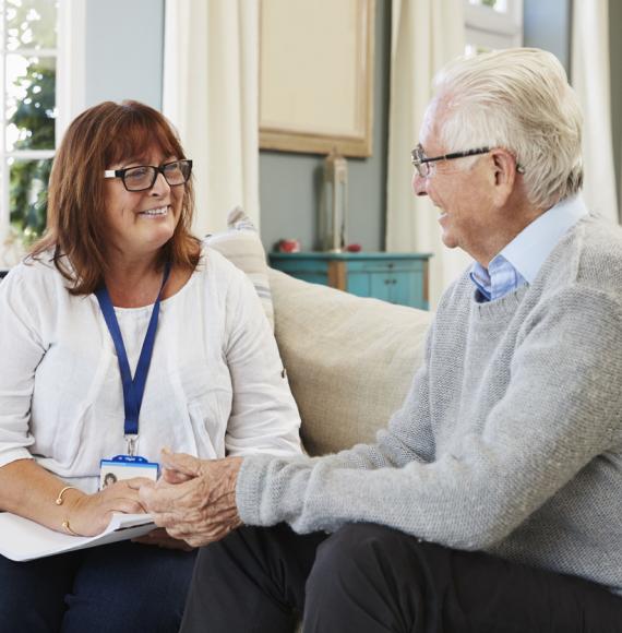 Female social care worker supporting older man