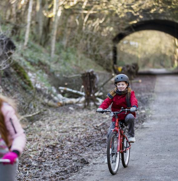 A family cycling through a park