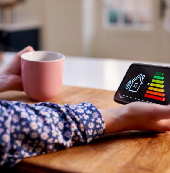 Woman holding a device measuring her heating