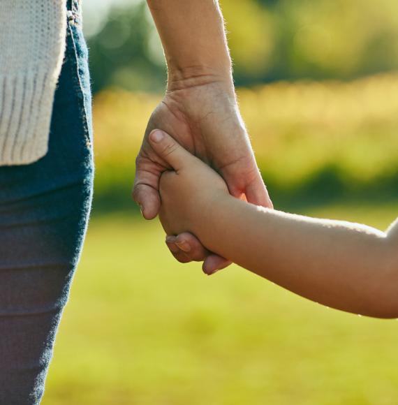 Woman and child holding hands on a sunny day