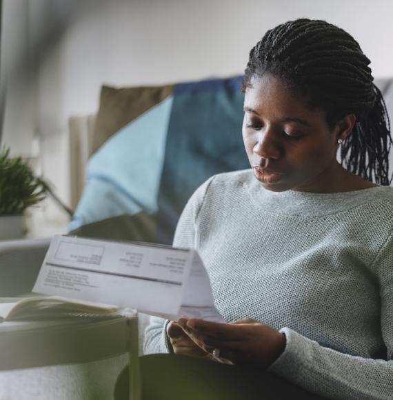 Young woman reading energy bill looking concerned