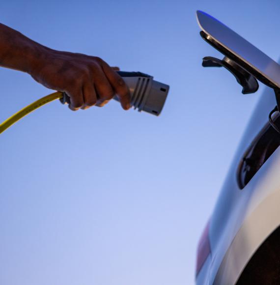 Person plugging an EV charger into an electric vehicle