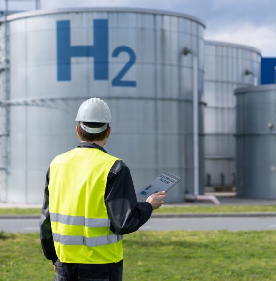 Man in hi vis in front of a hydrogen storage tank