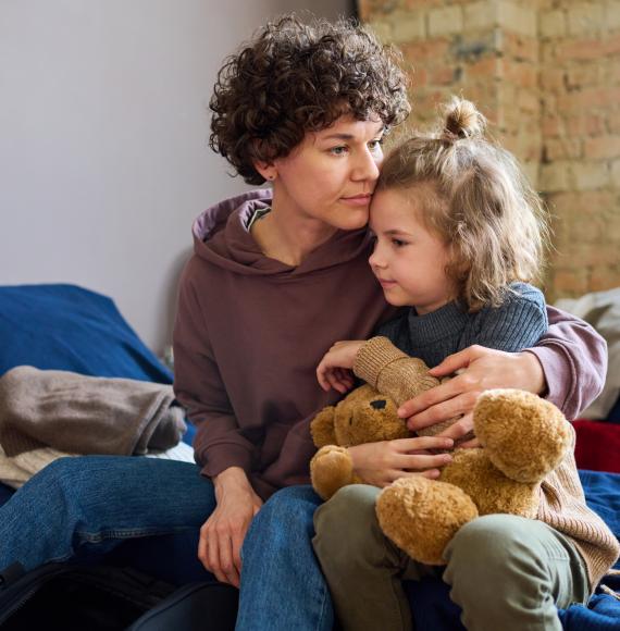 Homeless mother and daughter cuddling