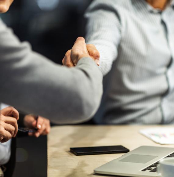 Two people shaking hands over a business agreement