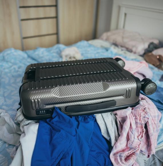 Suitcase on a bed of a temporary accomodation