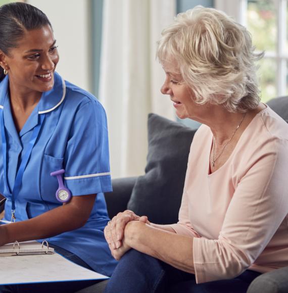 Social care worker sat with an older woman