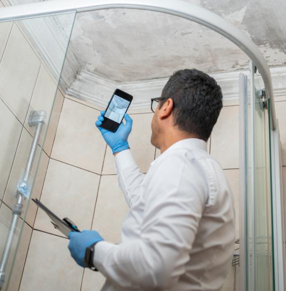 Man checking mould in a shower