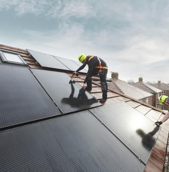 Men installing solar panels, a source of green energy