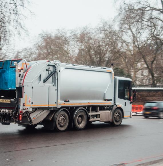 A garbage truck in the middle of a city